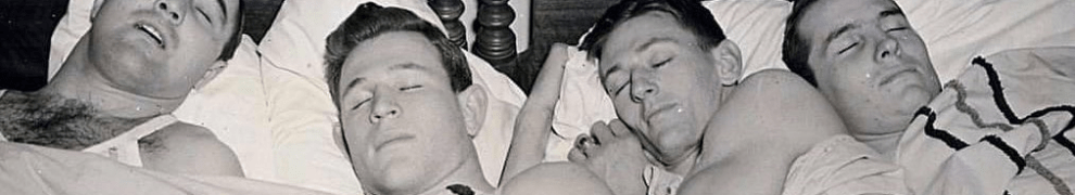 four men sleeping in bed